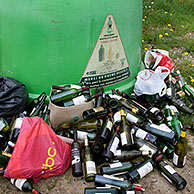 Glass collection point / Bottle bank with dumped wine bottles in front
